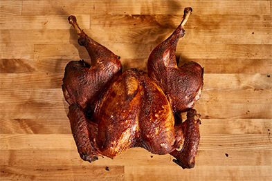 Spatchcocked whole roasted turkey on a wooden cutting board