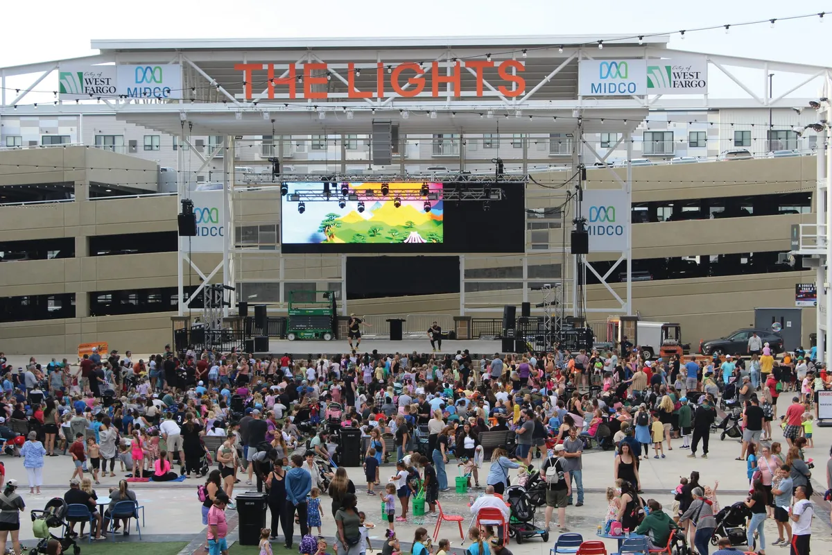 Large crowd gathered at The Lights outdoor venue in West Fargo beneath a large LED screen