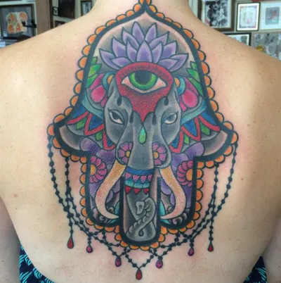 Colorful elephant hamsa back tattoo with lotus flower and third eye