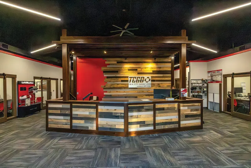 TCGD reception desk with reclaimed wood paneling and warm accent lighting inside a showroom