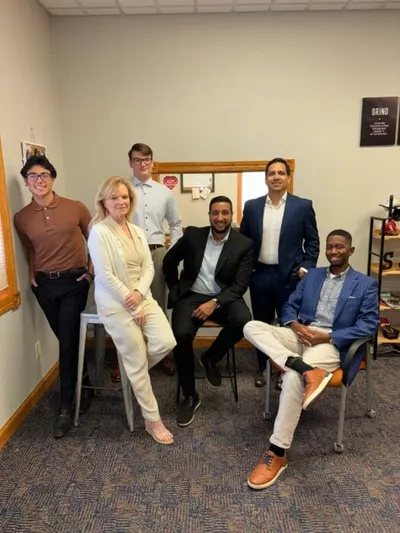 Six professionals posing together in a casual office setting