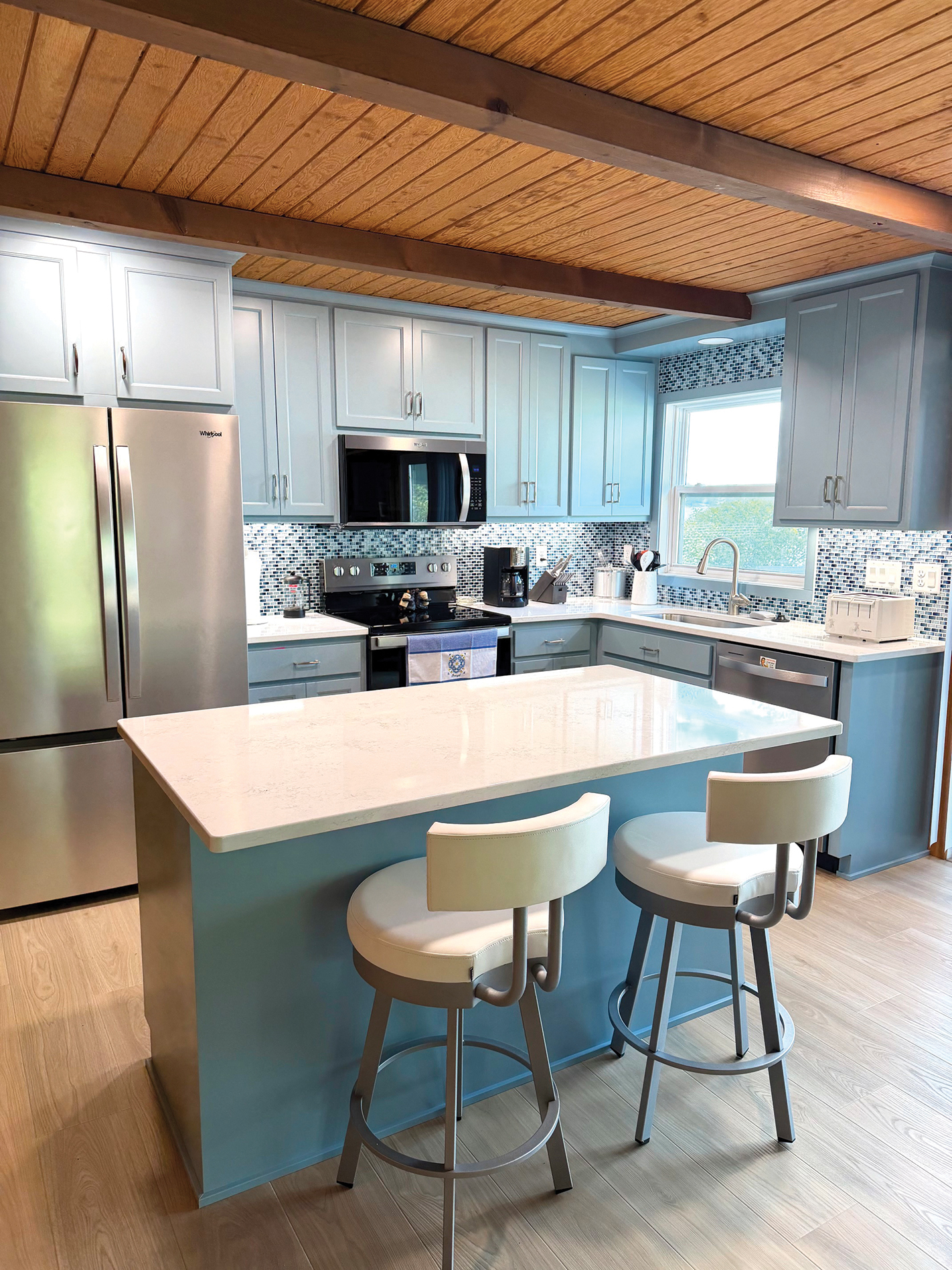 Blue kitchen island and seating in a remodeled lake cottage