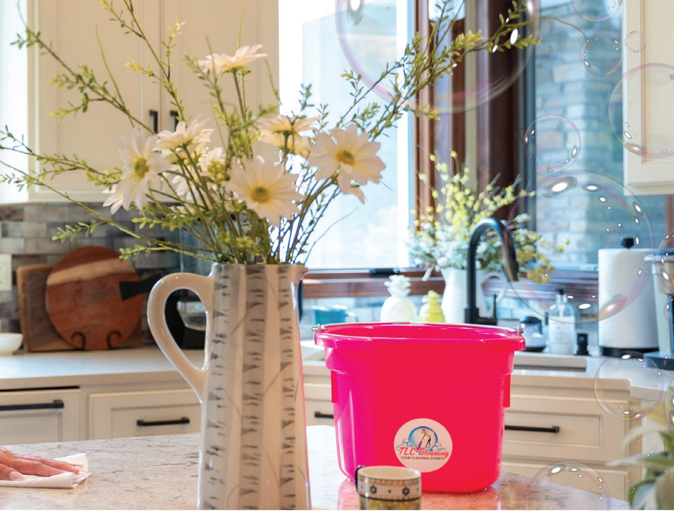 TLC Cleaning bucket on a kitchen counter with flowers