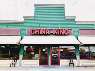 China King restaurant exterior with teal siding and red sign above striped awning