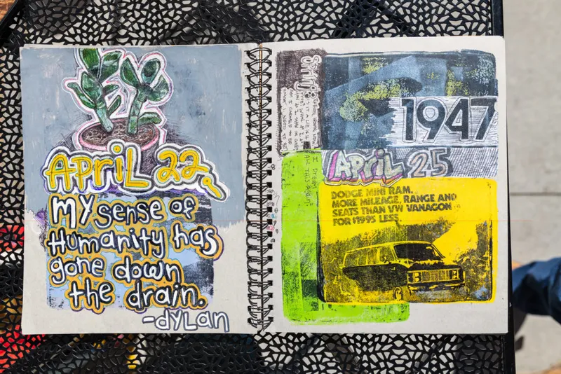 Open spiral sketchbook with hand-lettered journal entries and collaged van ad for April 22 and 25