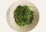 Bowl of sautéed greens with herbs and a light sauce