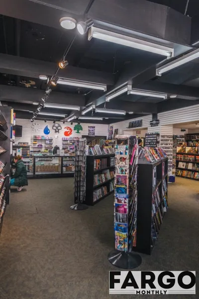 Interior of a comic and card shop with rotating racks and shelves of comics