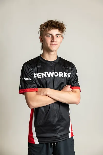 Young man in black Fenworks jersey standing with arms crossed