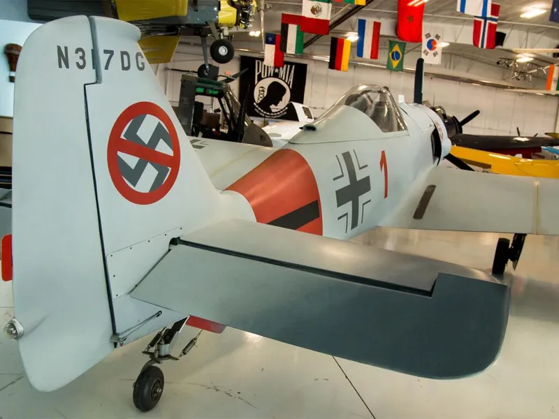 WWII-era warplane replica with German Luftwaffe markings on display inside an aviation museum