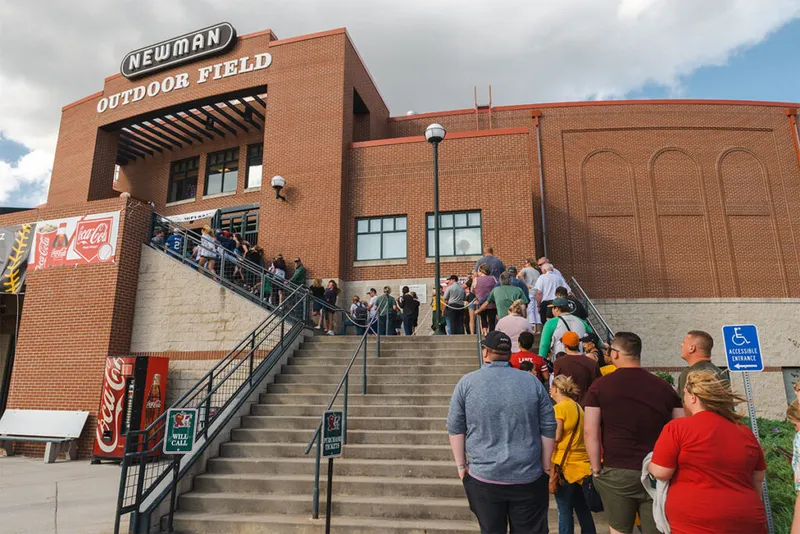 Crowd of fans lined up on steps outside Newman Outdoor Field's brick entrance