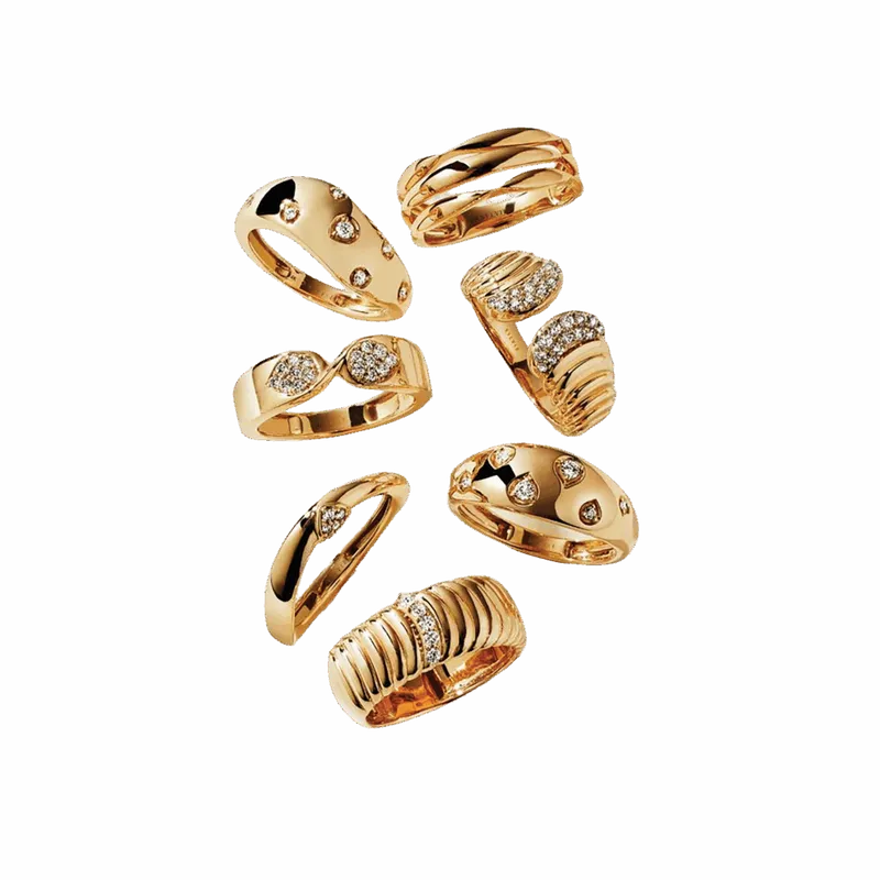Seven gold rings with diamond accents in varied styles on white background