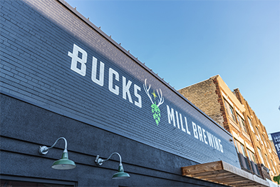 Bucks Mill Brewing painted signage with deer logo on dark brick exterior wall