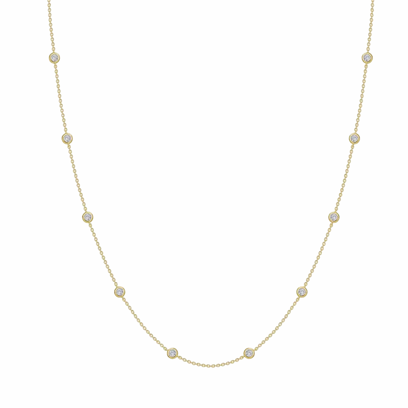 Delicate gold chain necklace with evenly spaced bezel-set clear round stones