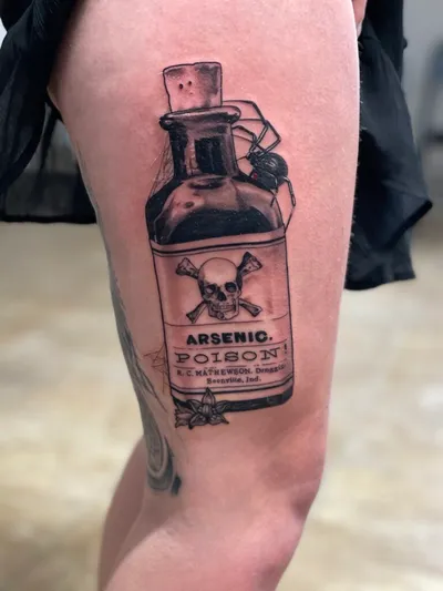 Black and grey tattoo of a poison bottle labeled 'Arsenic' with skull and crossbones and a spider