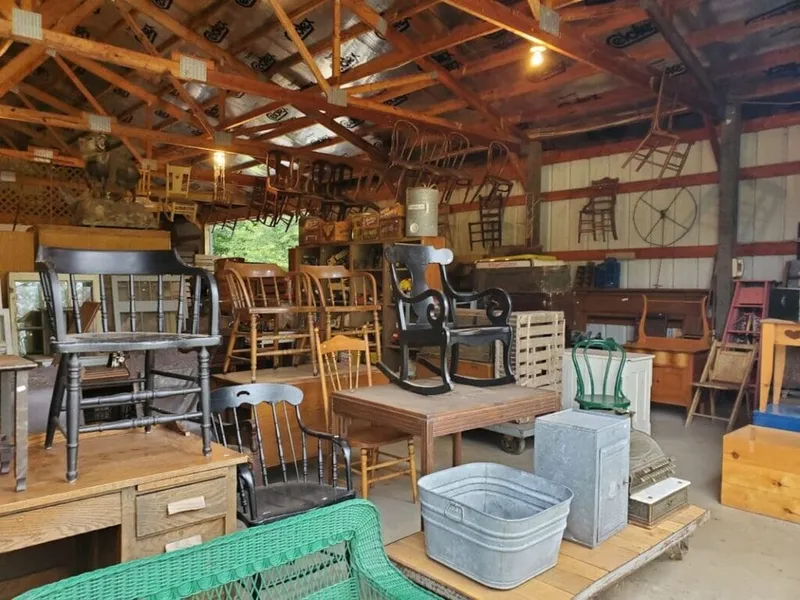 Rustic barn antique shop filled with vintage wooden chairs and galvanized metal tubs