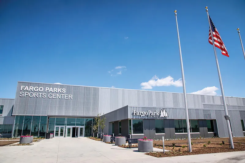 Fargo Parks Sports Center exterior with flagpoles and American flag under blue sky
