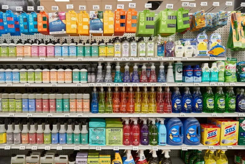 Store shelves stocked with colorful dish soaps, hand soaps, and cleaning supplies