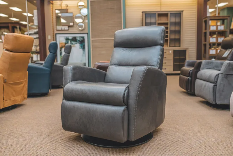 Gray leather swivel recliner on display in a furniture showroom