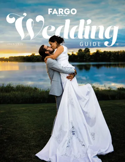bride and groom kissing in front of lake on their wedding day
