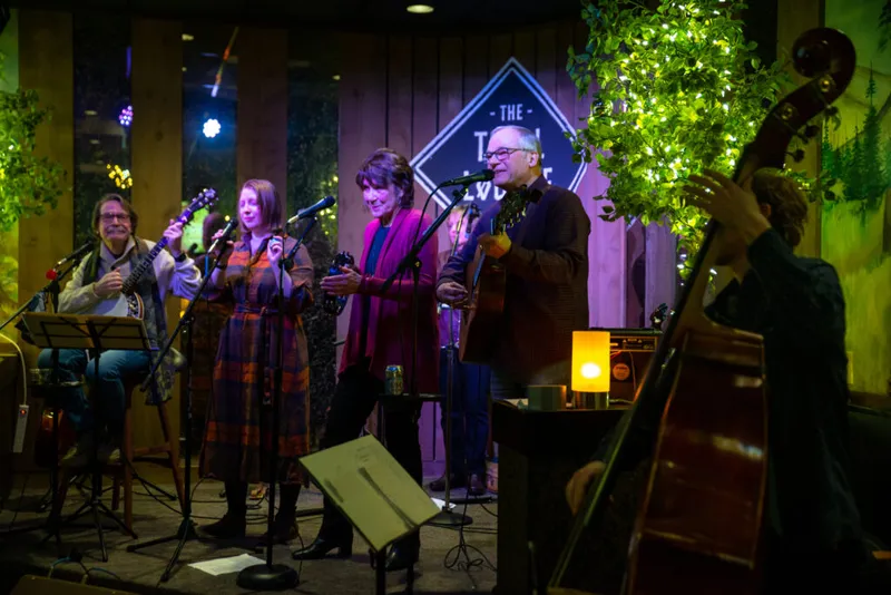 Four musicians performing on a small stage at the Troll Lounge, with a double bass player in the foreground