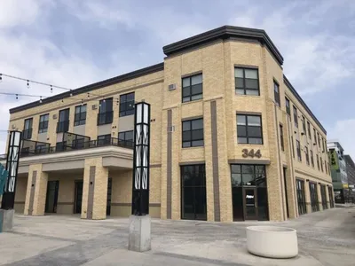 Three-story tan brick commercial building with address number 344