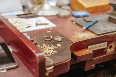 Gold rings and a chain laid on a worn red jewelry display case
