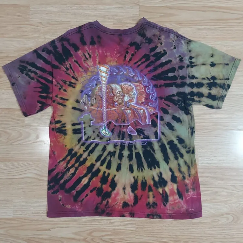 Tie-dye T-shirt in red, black, yellow, and green spiral pattern with a graphic print on the back
