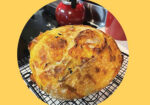 Golden round bread loaf on a wire cooling rack