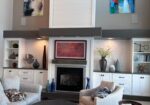 Bright living room with built-in white shelving, gas fireplace, and framed wall art