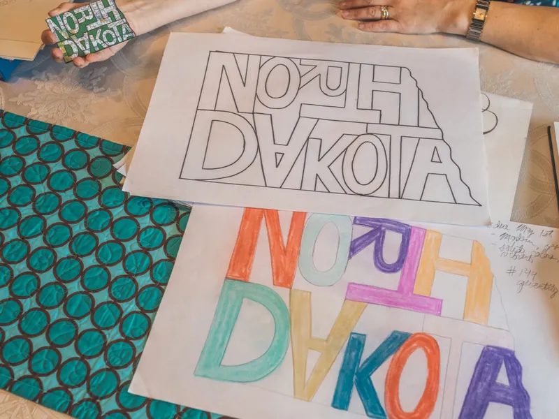 Hand-drawn North Dakota lettering sketches in outline and multicolor marker on a table