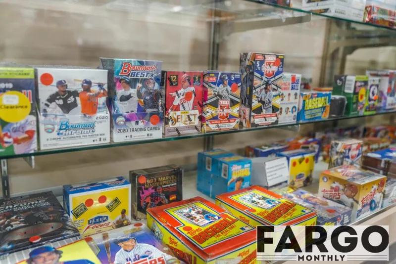 Glass shelves displaying baseball card boxes including Bowman Chrome and Topps sets in a retail shop