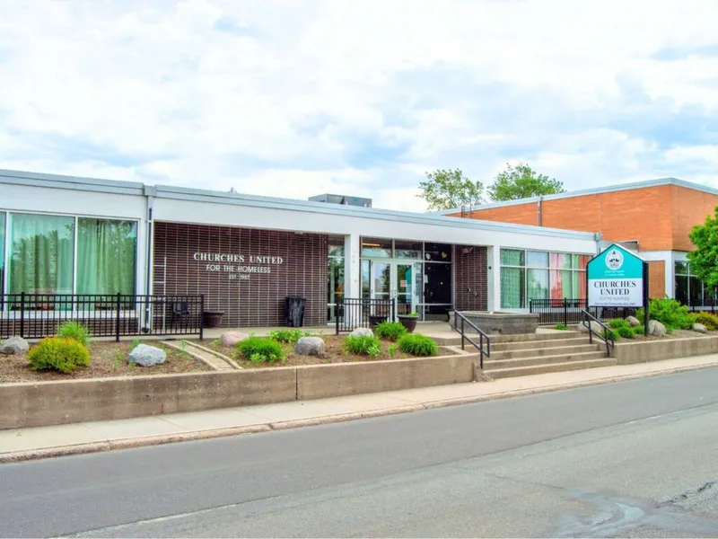 Churches United for the Homeless building exterior with teal sign and landscaped front