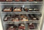 Packaged cuts of raw meat stacked on refrigerator shelves