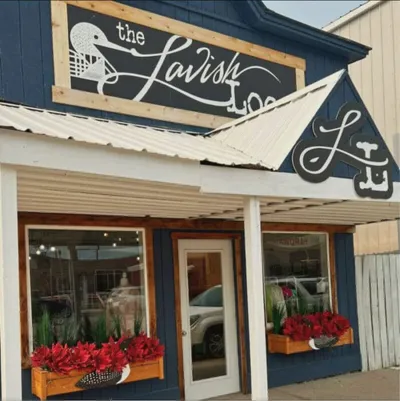 Storefront of The Lavish Loon boutique with red flower window boxes