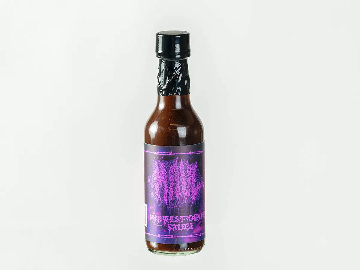 Small hot sauce bottle with dark purple label reading Midwest Death Sauce and metal music-style graphics