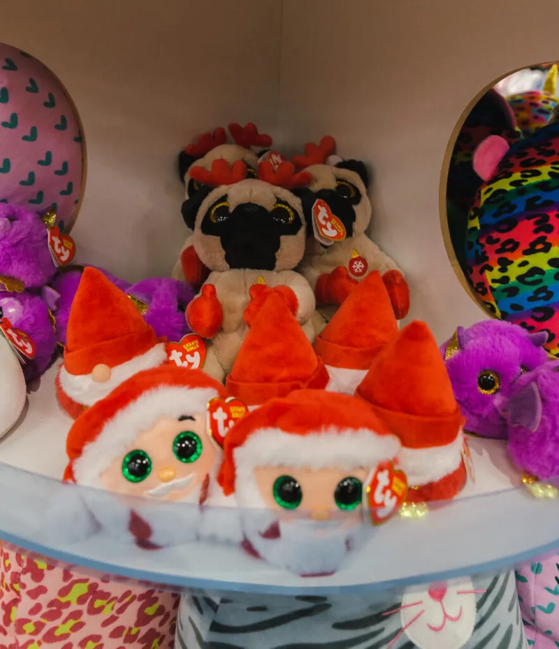 Ty Beanie Boo Santa and pug plush toys with glittery eyes on a store shelf