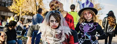 Children in zombie and witch Halloween costumes at an outdoor parade