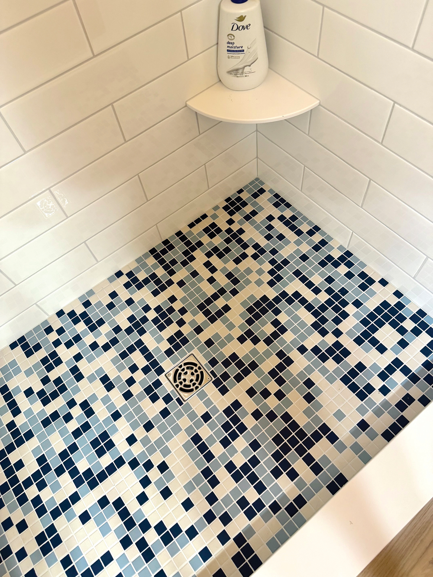 Blue and white mosaic tile on the primary shower floor