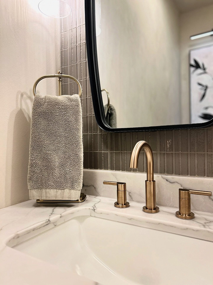 Brass faucet and towel detail in the renovated powder room