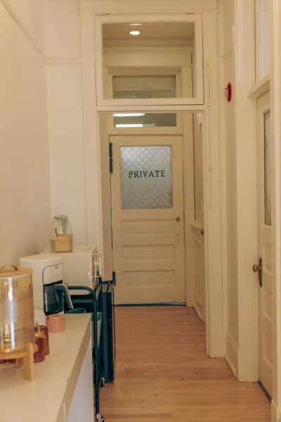 Narrow hallway leading to a white door with frosted glass marked 'PRIVATE