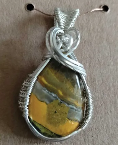 Wire-wrapped pendant featuring a yellow and grey banded stone