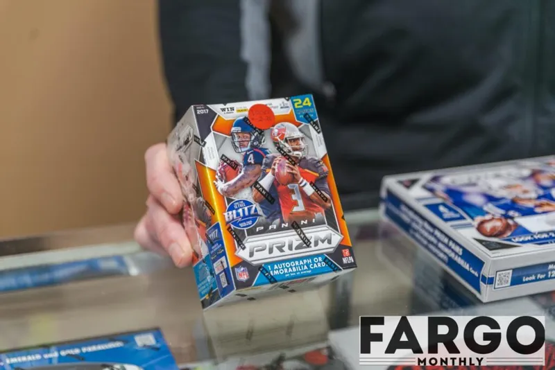Hand holding a 2017 Panini Prizm NFL football trading card blaster box