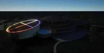 Aerial dusk rendering of a circular building with colorful illuminated lines on its roof