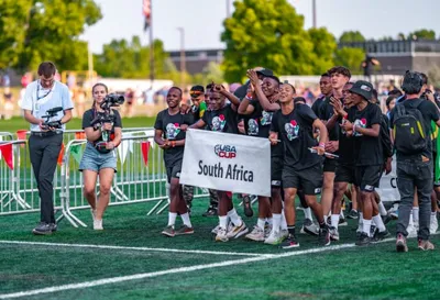 South Africa team marching with banner on a turf field during an opening ceremony