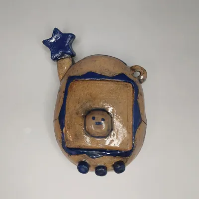 Handmade ceramic figurine with blue star, bear face, and glossy blue accents