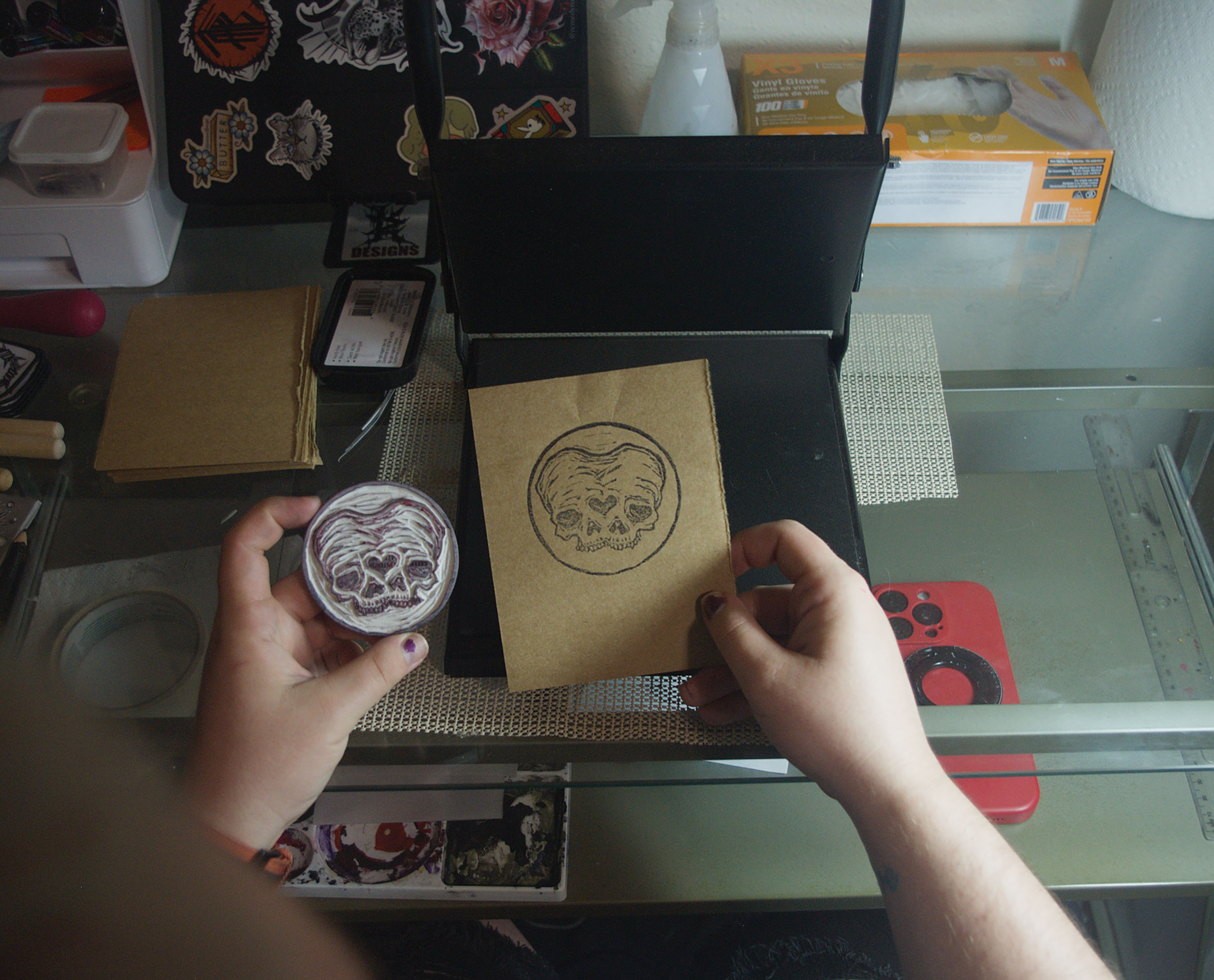 Hands revealing a freshly printed linocut