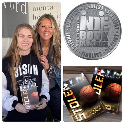 Two women holding a book titled Stolen, beside an Indie Book Awards Finalist medal and copies of the same book