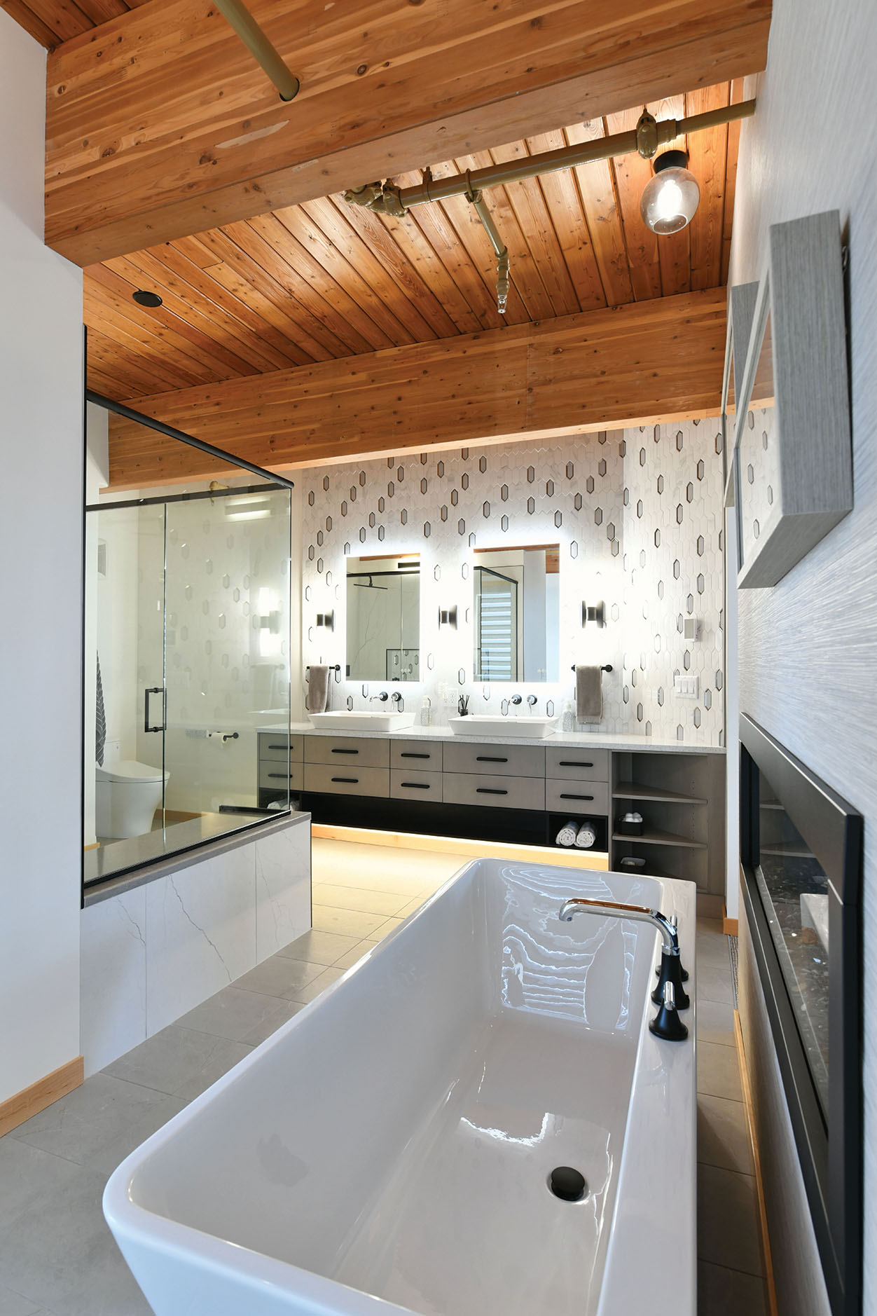 Freestanding tub beside a glass shower and double vanity