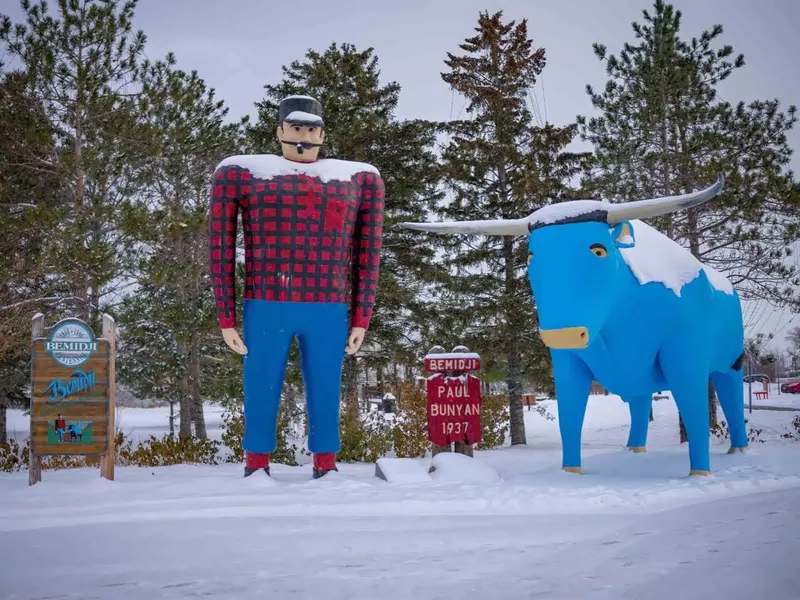 Snow-dusted Paul Bunyan and Babe the Blue Ox statues in Bemidji, Minnesota in winter