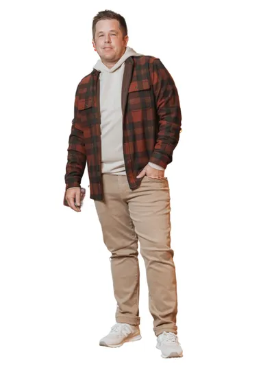 Man in red plaid flannel shirt jacket, cream hoodie, tan pants, and white sneakers